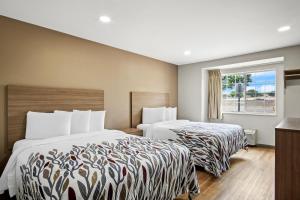 尤利斯Red Roof Inn & Suites Euless - DFW Airport Southwest的有两张床和一扇窗户的酒店房间 更多29张照片