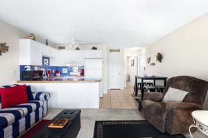 a living room with a couch and a kitchen at The Nook at Weston Point - Cozy Condo Getaway in Osage Beach