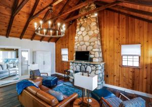 a living room with a stone fireplace and a tv at Como Collection - 2 Homes 2 Lakes 1 Rental in Lake Geneva +47 photos