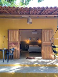 a bedroom with a bed and a wooden door at Chalés Borborema Cumuru in Prado