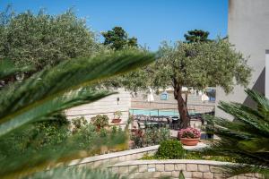 a garden with trees and plants in front of a building at Hotel Baia Del Capitano in Cefalù