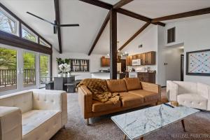 a living room with a couch and a table at Game Lovers Getaway In Abbey Springs with Golf Cart in Lake Geneva