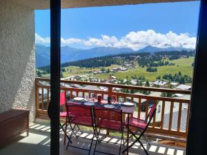 a table and chairs on a balcony with a view at Appartement chalet en plein centre des Saisies in Hauteluce