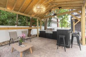 a pavilion with a kitchen and a table and chairs at 4 BDR Lake Geneva Estate Across from Beach in Lake Geneva