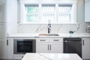 a kitchen with white cabinets and a sink and a window at 4 BDR Lake Geneva Estate Across from Beach in Lake Geneva +51 photos