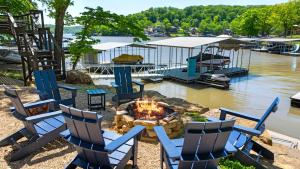 un groupe de chaises et un foyer à côté d'un plan d'eau dans l'établissement Little Bearcat Bungalow - Stay on Ozark Waterfront, à Sunrise Beach