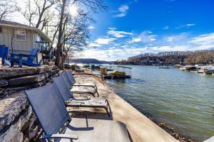 une rangée de chaises assises à côté d'un plan d'eau dans l'établissement Little Bearcat Bungalow - Stay on Ozark Waterfront, à Sunrise Beach