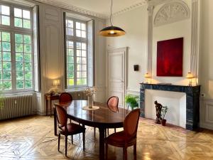 a dining room with a table and chairs and a fireplace at Hôtel Particulier, Maison Jazey. in Semur-en-Auxois