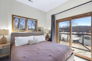 una camera da letto con un letto grande e una grande finestra di Bearcat Bungalows - Two Homes One Rental - Sleeps 22 a Sunrise Beach