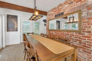 a dining room with a brick wall and a wooden table at CC Cabin - Full Game Room & Wrap Around Deck in Shaver Lake