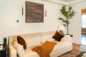 a living room with a white couch with brown pillows at Magnolia Manor - Remodeled Home Near Downtown in Lake Geneva