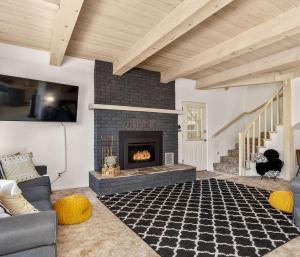 a living room with a fireplace and a couch at Cavu Cabin - A Classic Mountainside Escape in Shaver Lake