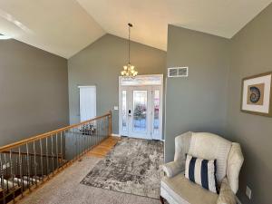 sala de estar con silla y escalera en Lake It Easy - Waterfront Getaway with 7 Bedrooms, en Rocky Mount