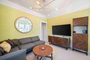 a living room with a couch and a flat screen tv at Aldrich House - PG Charmer Walk to Lovers Point in Pacific Grove