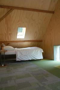 1 dormitorio con 1 cama en una habitación de madera en Klein Dubbelland, en Doorn