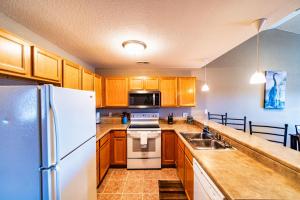 a kitchen with wooden cabinets and a white refrigerator at Highland Lake View - Incredible Location in Lake Ozark +20 photos
