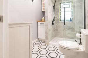 a bathroom with a shower and a toilet and a sink at Chic Downtown Lake Geneva Apartment - Sleeps 2 in Lake Geneva