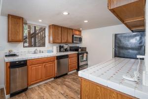 a kitchen with wooden cabinets and stainless steel appliances at Yosemite Quail - Nestled in with a View in Yosemite West