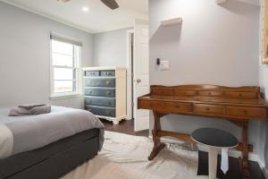 a bedroom with a bed and a dresser and a piano at Chic Downtown Lake Geneva Apartment - Sleeps 2 in Lake Geneva