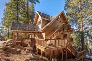 a house with a wrap around deck in the woods at Yosemite Quail - Nestled in with a View in Yosemite West