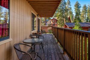 a patio with two tables and chairs on a balcony at Yosemite Quail - Nestled in with a View in Yosemite West