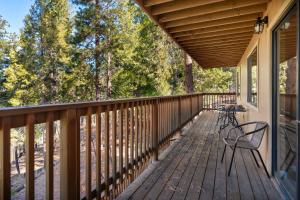 a wooden deck with two chairs on it at Yosemite Quail - Nestled in with a View in Yosemite West
