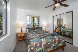 a bedroom with a bed and two lamps and a fan at Yosemite Quail - Nestled in with a View in Yosemite West