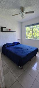 une chambre avec un lit avec une couette bleue et une fenêtre dans l'établissement Casa con Alberca en Ixtapa Zihuatanejo Internet, à Ixtapa 10 autres photos