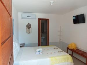 a white bedroom with a bed and a bathroom at Pousada Algas Marinhas in Mangue Sêco