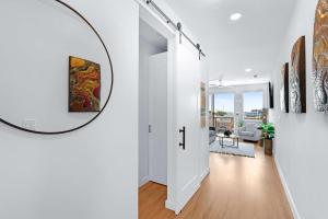 a hallway with white walls and a round mirror on the wall at Modern Hill Country Condo for 4 with Resort Perks in New Braunfels