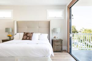 a bedroom with a white bed and a balcony at A True Vacation Masterpiece in Corona del Mar +18 photos