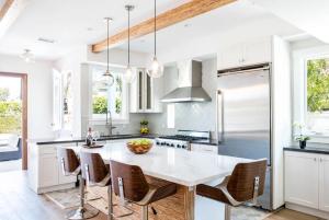 a white kitchen with a large white table and chairs at A True Vacation Masterpiece in Corona del Mar
