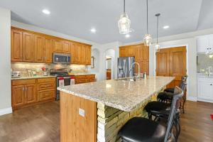 a kitchen with wooden cabinets and a marble counter top at Beautiful Lakefront Cabin - Something For Everyone in New Braunfels