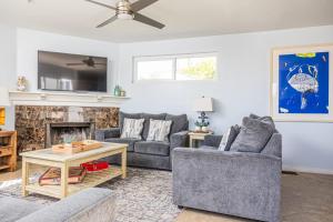 Una sala de estar con dos sofás y una chimenea. en Balboa Escape An Iconic Stay, en Newport Beach