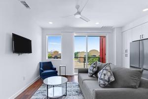 a living room with a couch and a table and a tv at Chic Condo Minutes to Downtown Gruene & More in New Braunfels