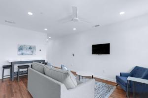 a living room with a couch and a tv on a wall at Chic Condo Minutes to Downtown Gruene & More in New Braunfels