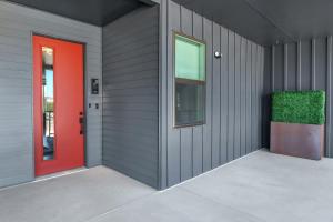 a building with a red door and a window at Pacific Island Inspired Stay - Amazing Location in New Braunfels