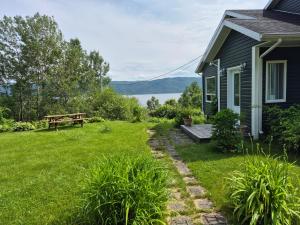 einen Hinterhof mit einem Picknicktisch und einem Haus in der Unterkunft Villa de la Montagne in Sainte-Rose-du-Nord