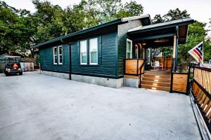 a green tiny house with a large driveway at Best Location in Downtown NB - Golf Cart Included in New Braunfels