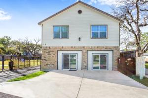a white house with doors and a fence at Spacious Retreat & Game Room - Sleeps 8 in New Braunfels