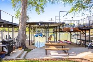 a park with a playground with a tree and benches at Beautiful and Relaxing Lakefront Getaway in New Braunfels