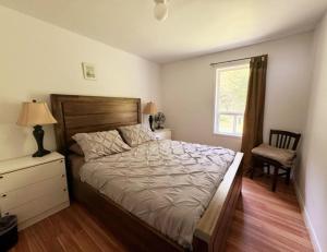 ein Schlafzimmer mit einem Bett und einem Stuhl und einem Fenster in der Unterkunft Villa de la Montagne in Sainte-Rose-du-Nord