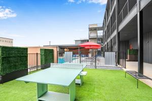 a patio with a table and benches on the grass at Creekside Modern - Condo for 4 in New Braunfels