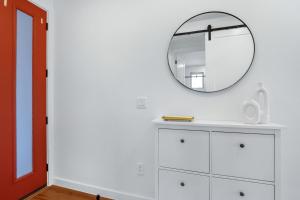 a white bathroom with a mirror and a dresser at Creekside Modern - Condo for 4 in New Braunfels