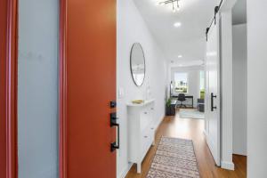 a hallway with an orange door and a white cabinet at Creekside Modern - Condo for 4 in New Braunfels