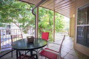 eine abgeschirmte Veranda mit einem Tisch und Stühlen in der Unterkunft Waterwheel Hideaway - Cozy Condo for 6 with Resort-style Amenities in New Braunfels