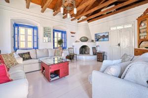 a living room with white furniture and a fireplace at Villa Archontissa in Spetses