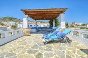 a blue chair sitting on a stone patio at Villa Archontissa in Spetses