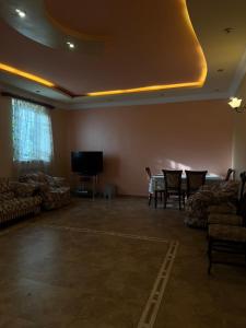 a living room with a table and chairs and a tv at Гостевой дом в Антаруте in Tekher +15 photos