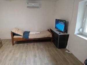 a small room with a bed and a television at Enikő Vendégház in Vajdácska